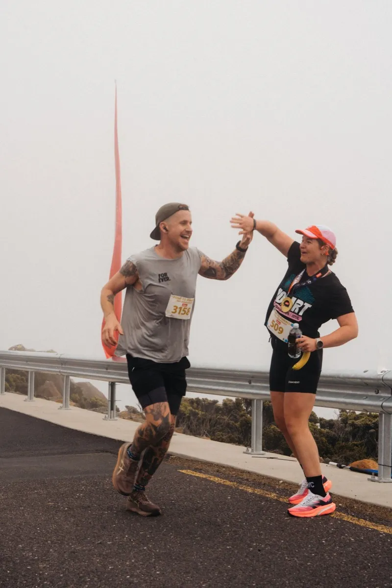 Two runners high-fiving on the course